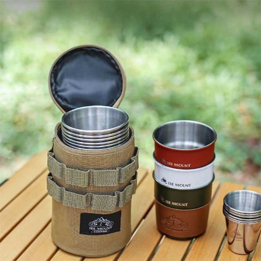 ISE MOUNT stainless steel camping cup set with a fabric carry case on a wooden table